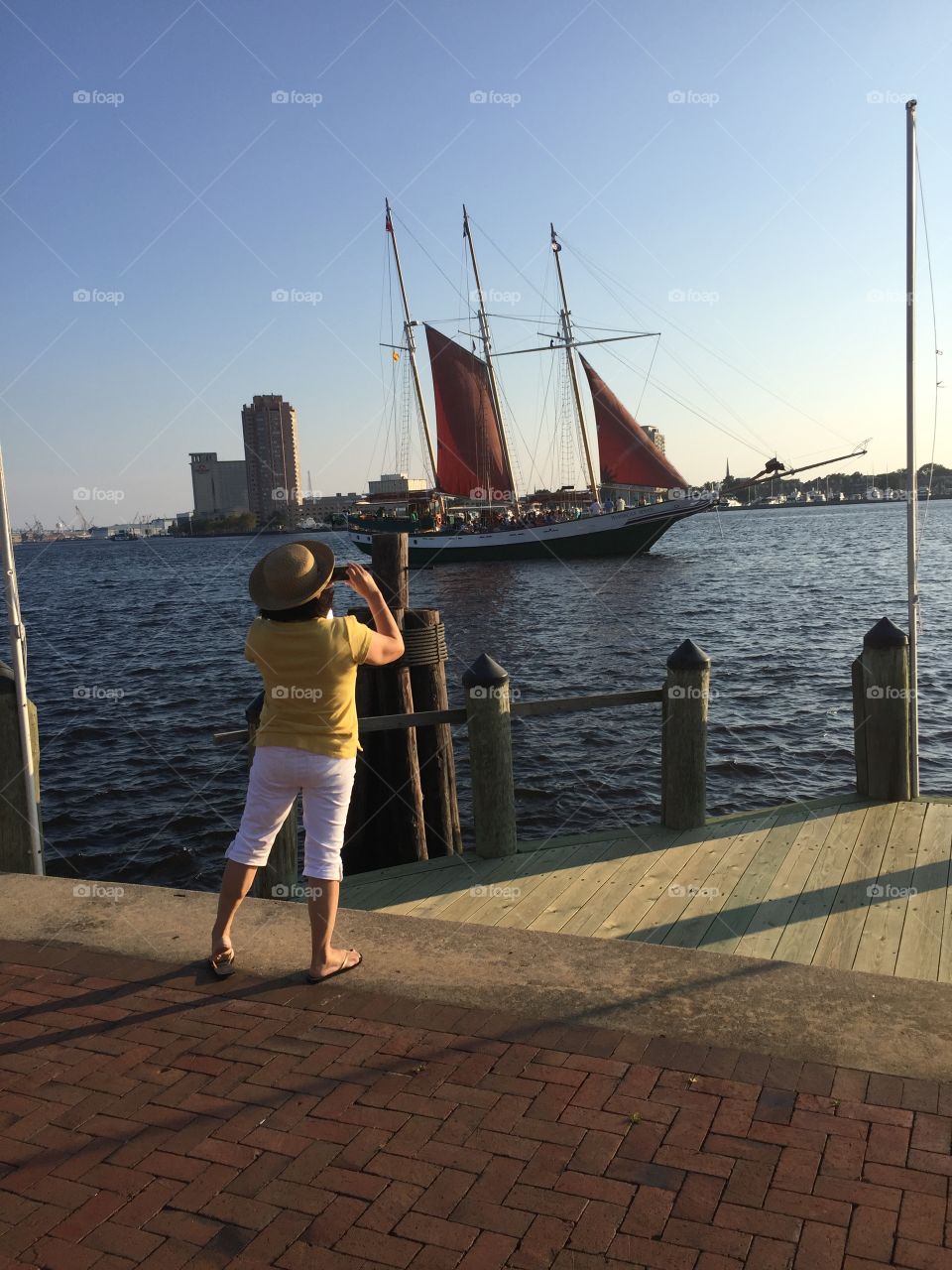 Woman takes photo of sailboat