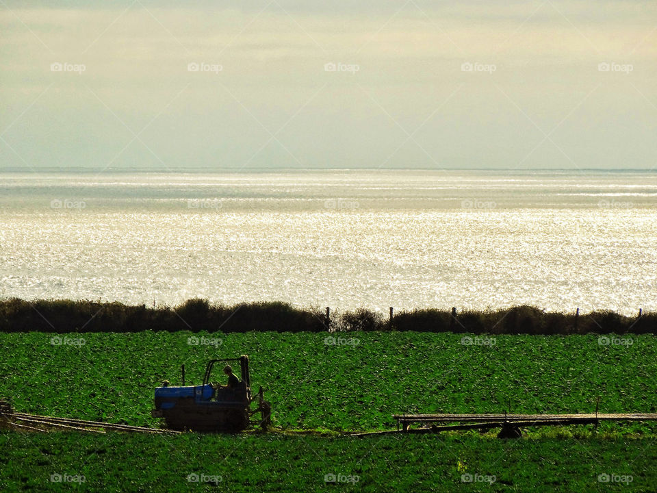 Tractor tilling a seaside field