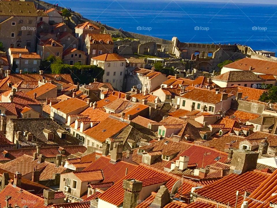 The bright orange tile roofs of Dubrovnik, Croatia and the bright blue of the Adriatic Sea on a hot summer day.