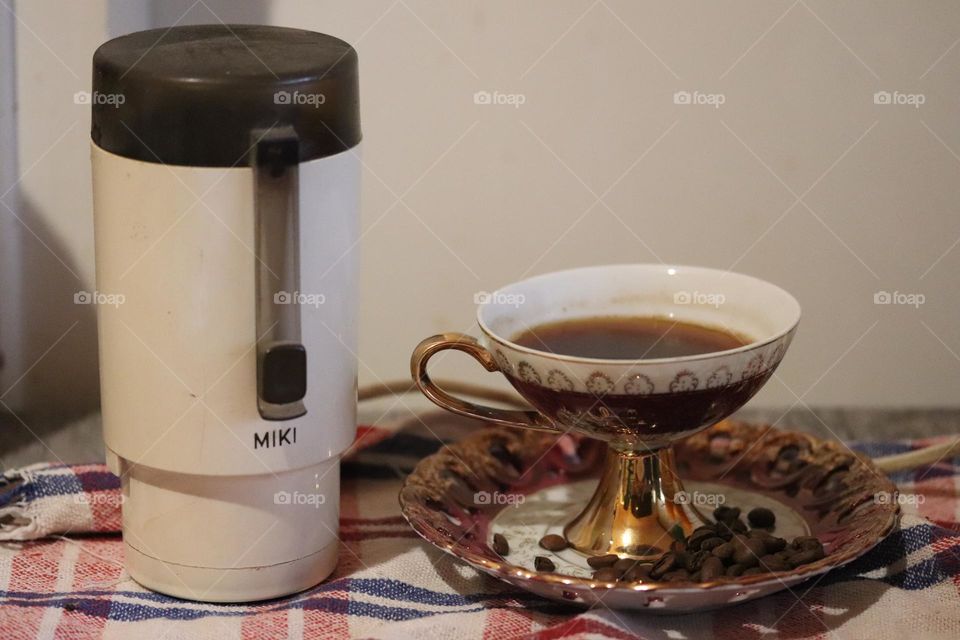 Grinder, cup and coffee beans