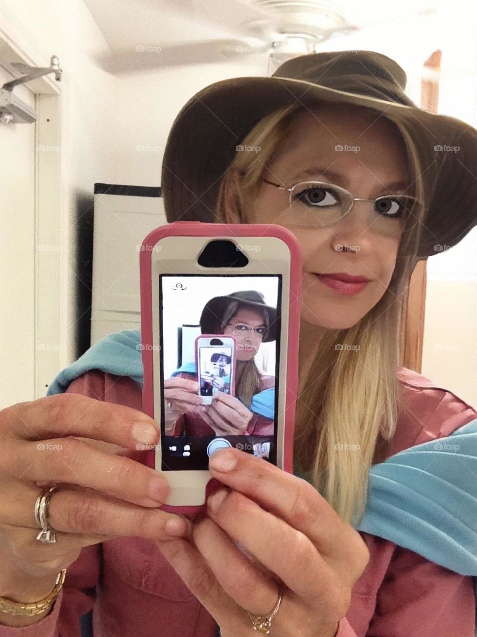 Woman taking her photo in a mirror to infinity.