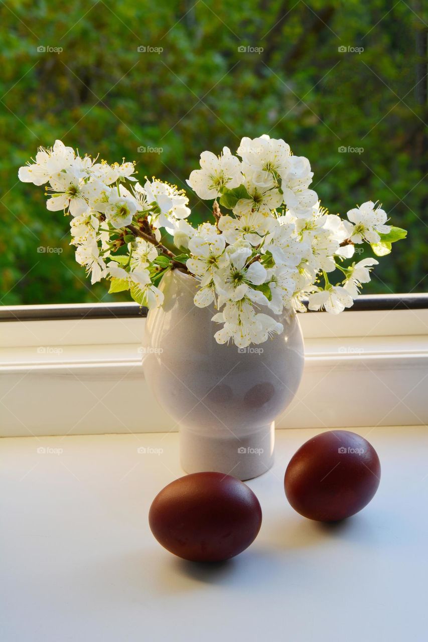 spring flowers in vase and red eggs Easter holiday