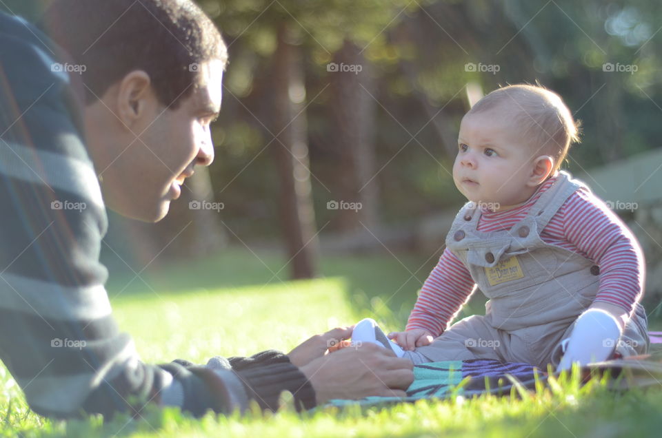 Father and baby looking at each other in garden