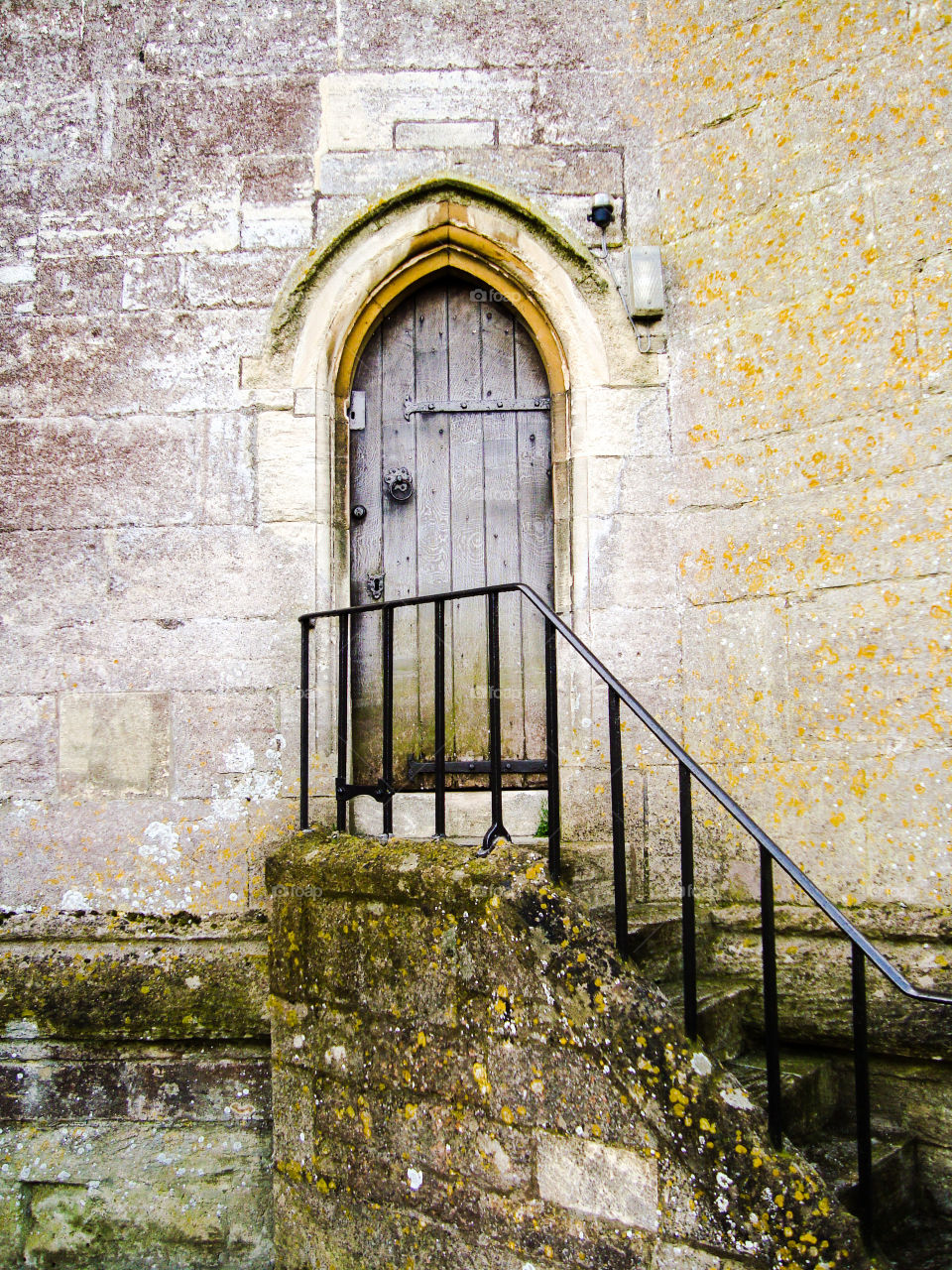 Old stone church timber door with steps and moss