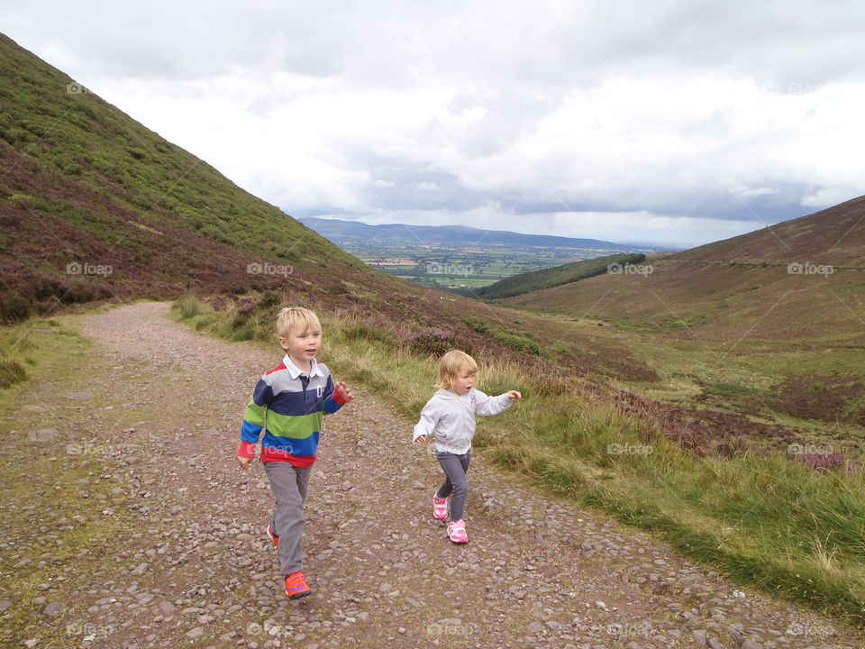 Brother and sister walking on dirt road