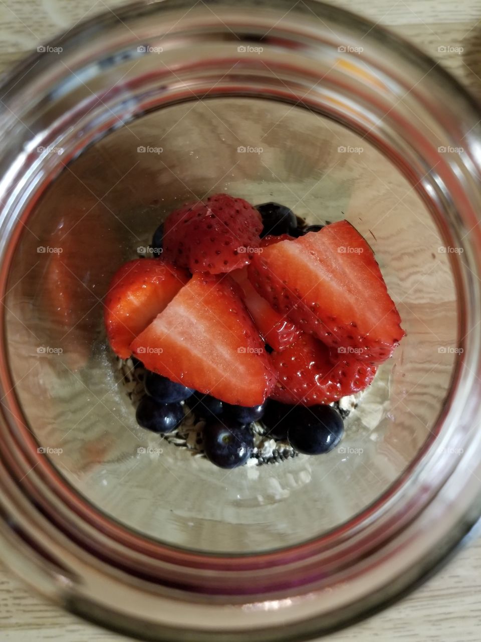 Strawberries and Blueberries in a Mason jar with oats almond milk and chia seeds. Overnight oats at its yummiest!!