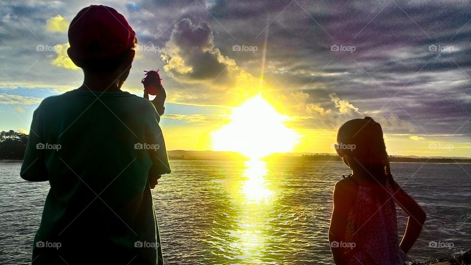 Sunset over sea with kids