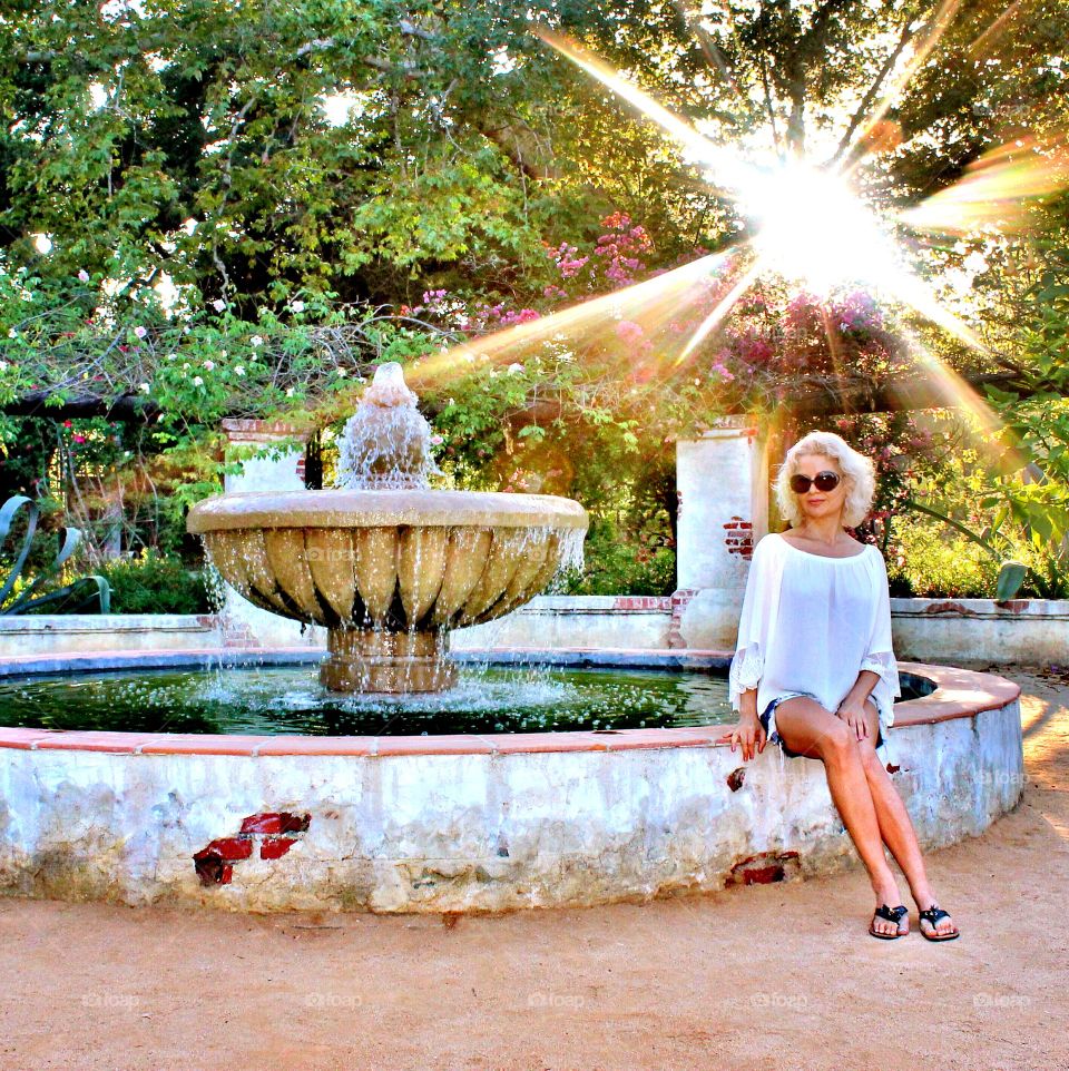 Woman sitting near fountain