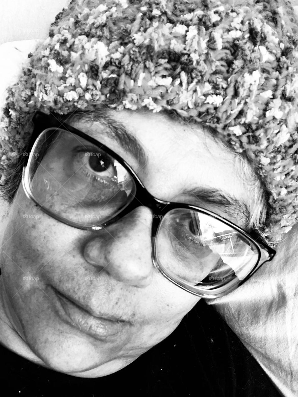 Woman in a wool hat shows her emotions for being stuck indoors during a particular cold winter weekend. 