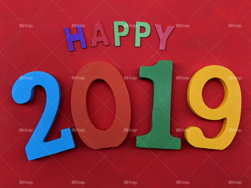 Happy 2019 with wooden numbers and letters over red board