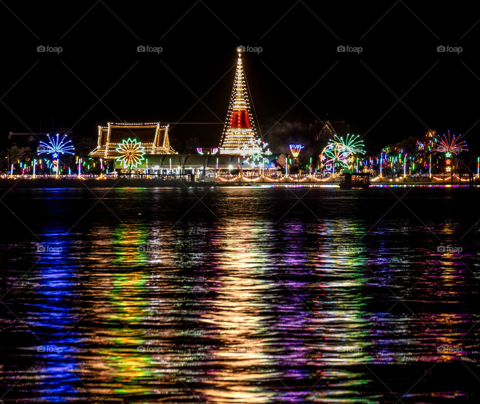 The beautiful light and reflection on the river of the pagoda Celebration in the Thai Temple Fair