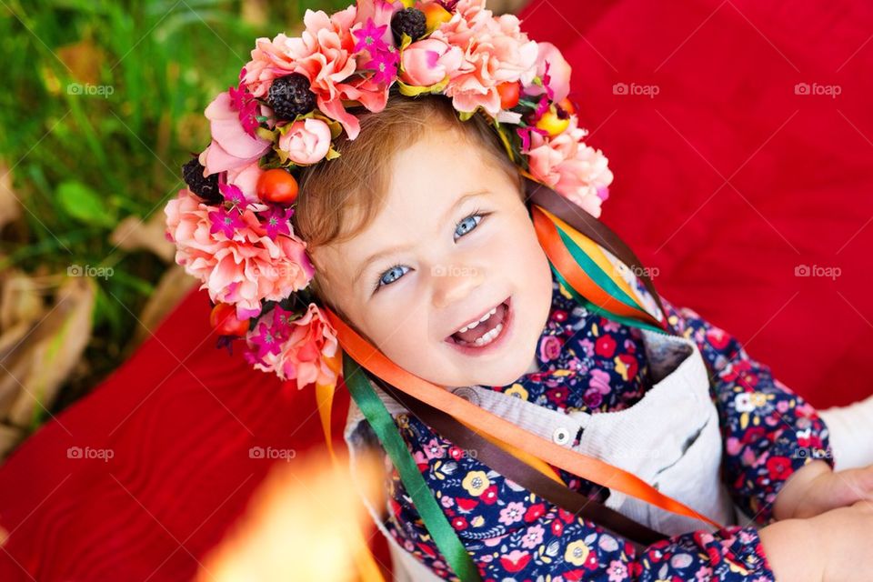 Cute girl in a wreath of flowers