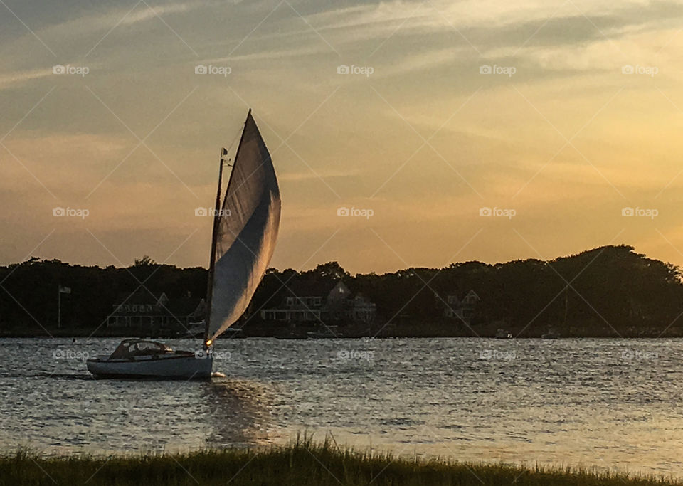 Closer...she’s sailing home during sunset, hoping to make it back before darkness sets. 
