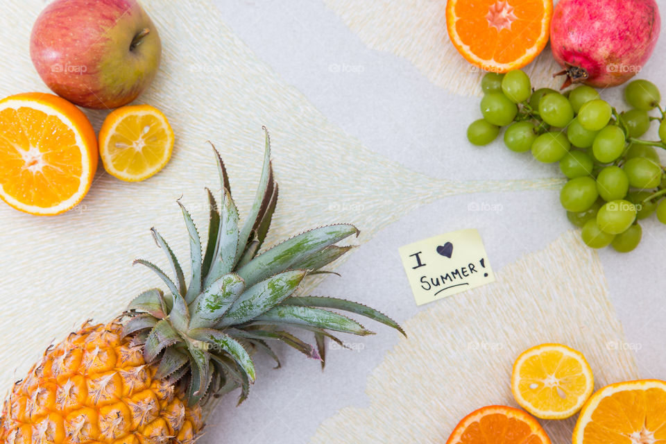 I love summer sticky note on a textured background with fresh fruit sliced and whole. Vibrant colours and full of life. Summer fresh fruit for a healthy diet.
