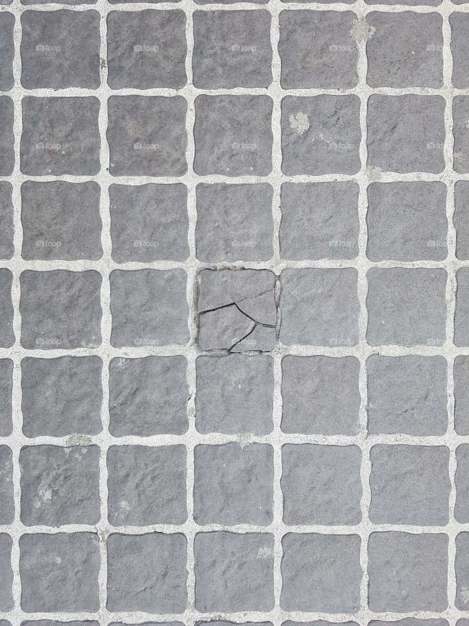 background texture of a checker stone flooring with one broken tile in the middle