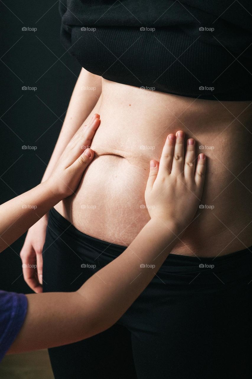 girl is touching mothers belly