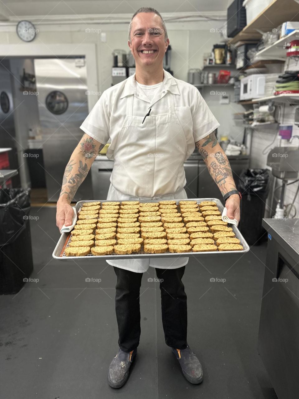 Chef bakes cookies, making cookies in a restaurant, baking cookies from scratch, new cookie recipe, chef holds large tray of cookies in kitchen 