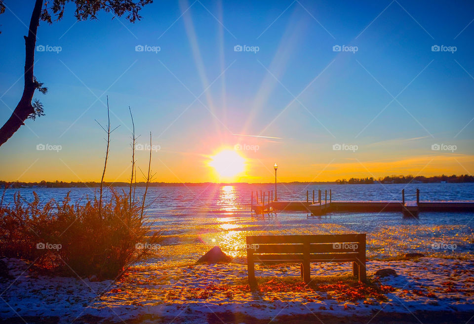 Breathtaking sunset moment on a cold winter's day. Empty bench to sit and just take in the beauty of mother nature, with scenery that's so peaceful.