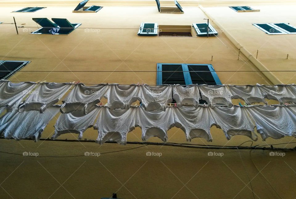 multiple white undershirt drying outdoors