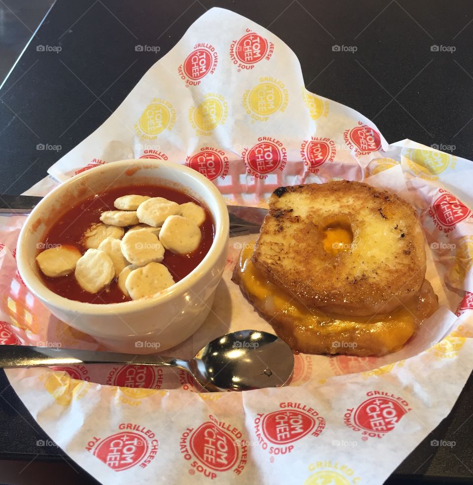 Glazed donut grilled cheese with a side of tomato soup. 
Tom & Chee restaurant.