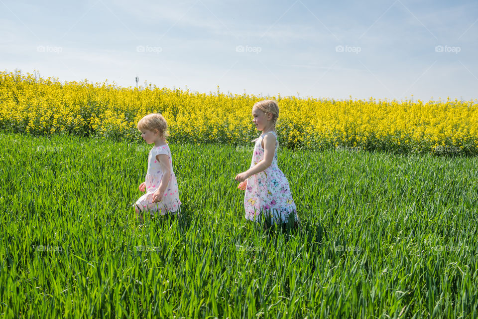 Two girls walking in grassy field