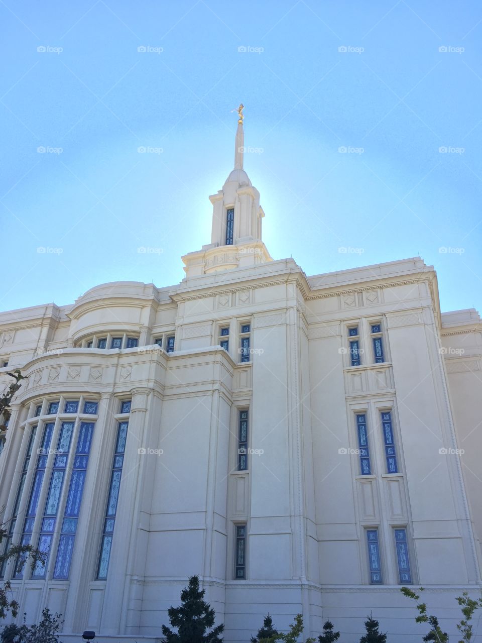 upward shot of the Payson Utah LDS Temple. a heavenly glow surrounds the tower and Angel Moroni. 
