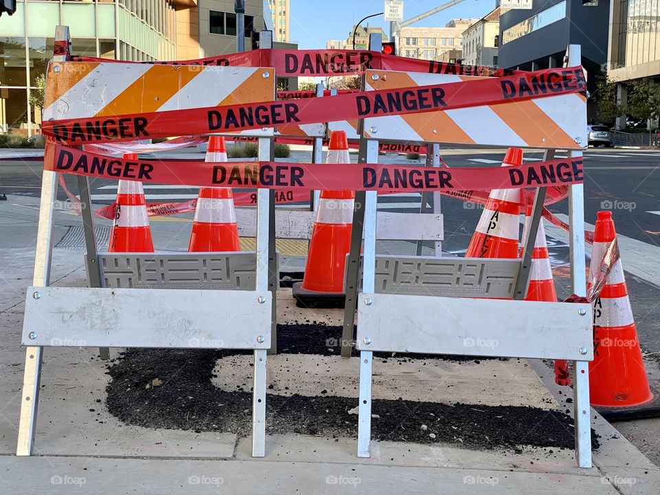 Red danger tape closing off repair area on sidewalk