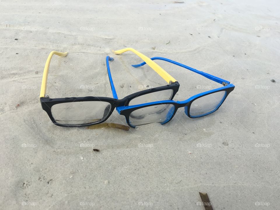 Eyeglasses together seeing the future slightly submerge on the seashore.
