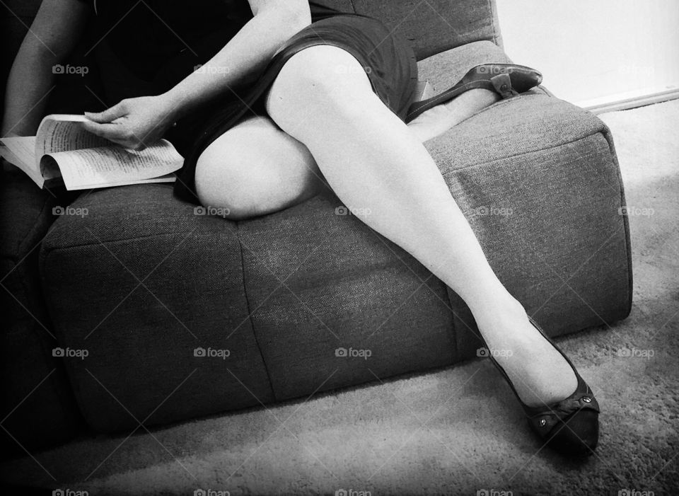Women sitting in a sofa reading a book
