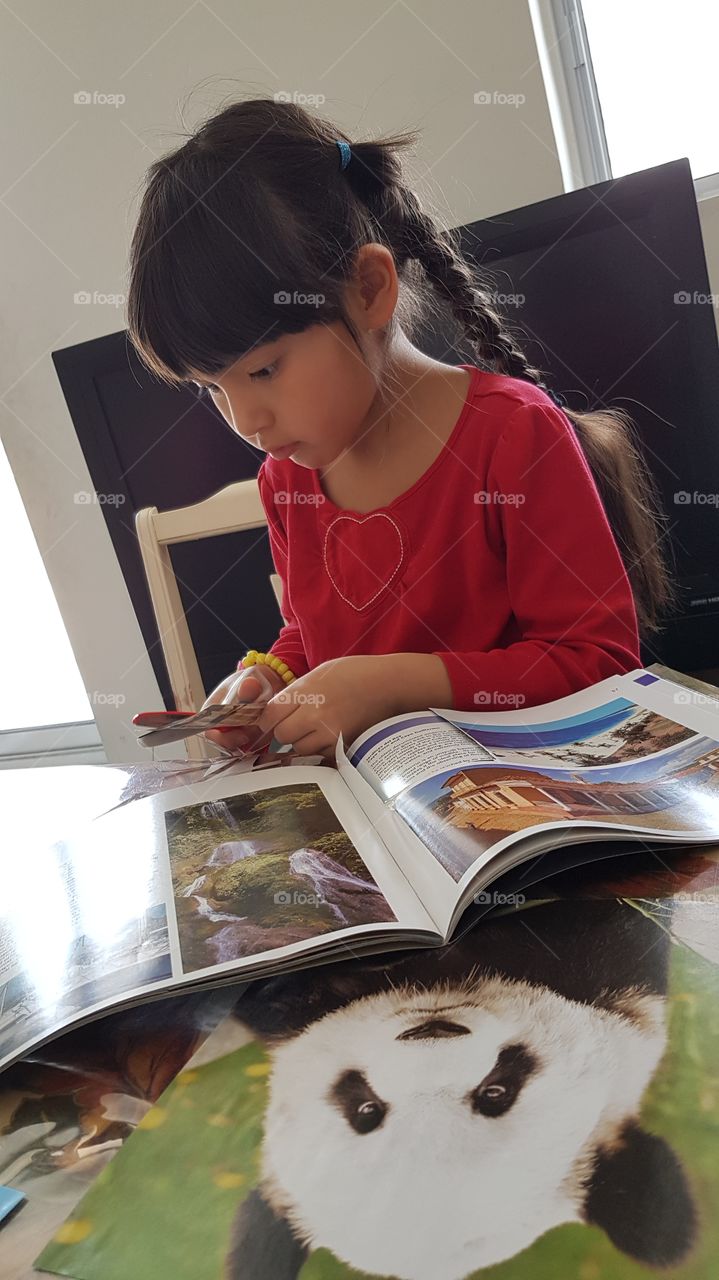 Young girl is busy making her own dream board