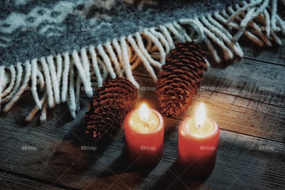 Candle red color flame close-up cones plaid wrap wood background decoration textured celebration winter