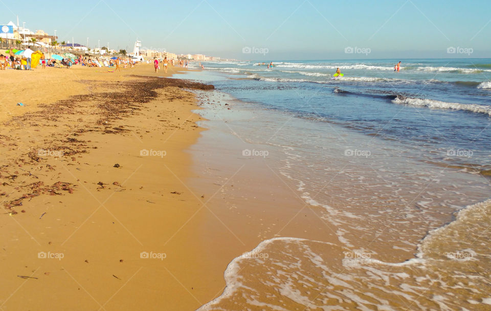 Sunny sandy  beach with some people in the distance