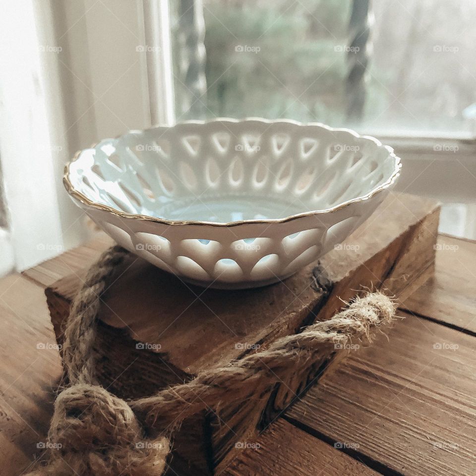 Vintage bowl with holes on wooden stand