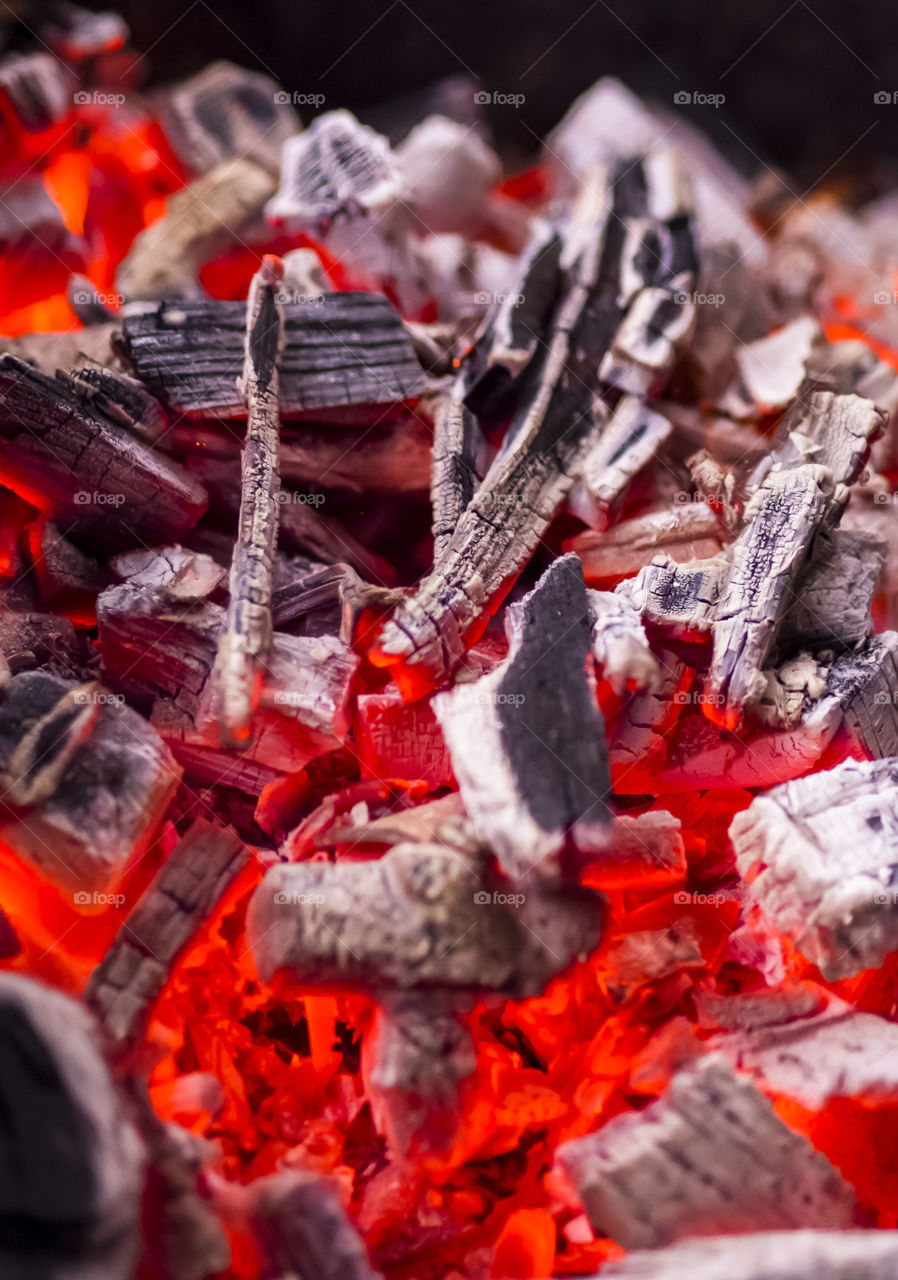 A burning fire burns to coals with a bright red-yellow flame for roasting meat.