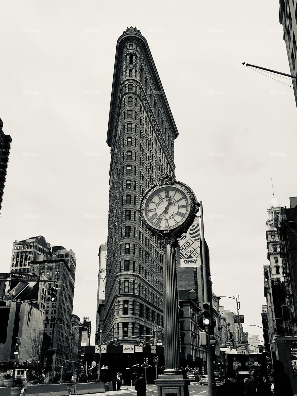 Low angle view of Flatiron building and street Tiffany clock on the 5th Avenue in New York, one of the most iconic architecturally unique building, iconic spot in black and white