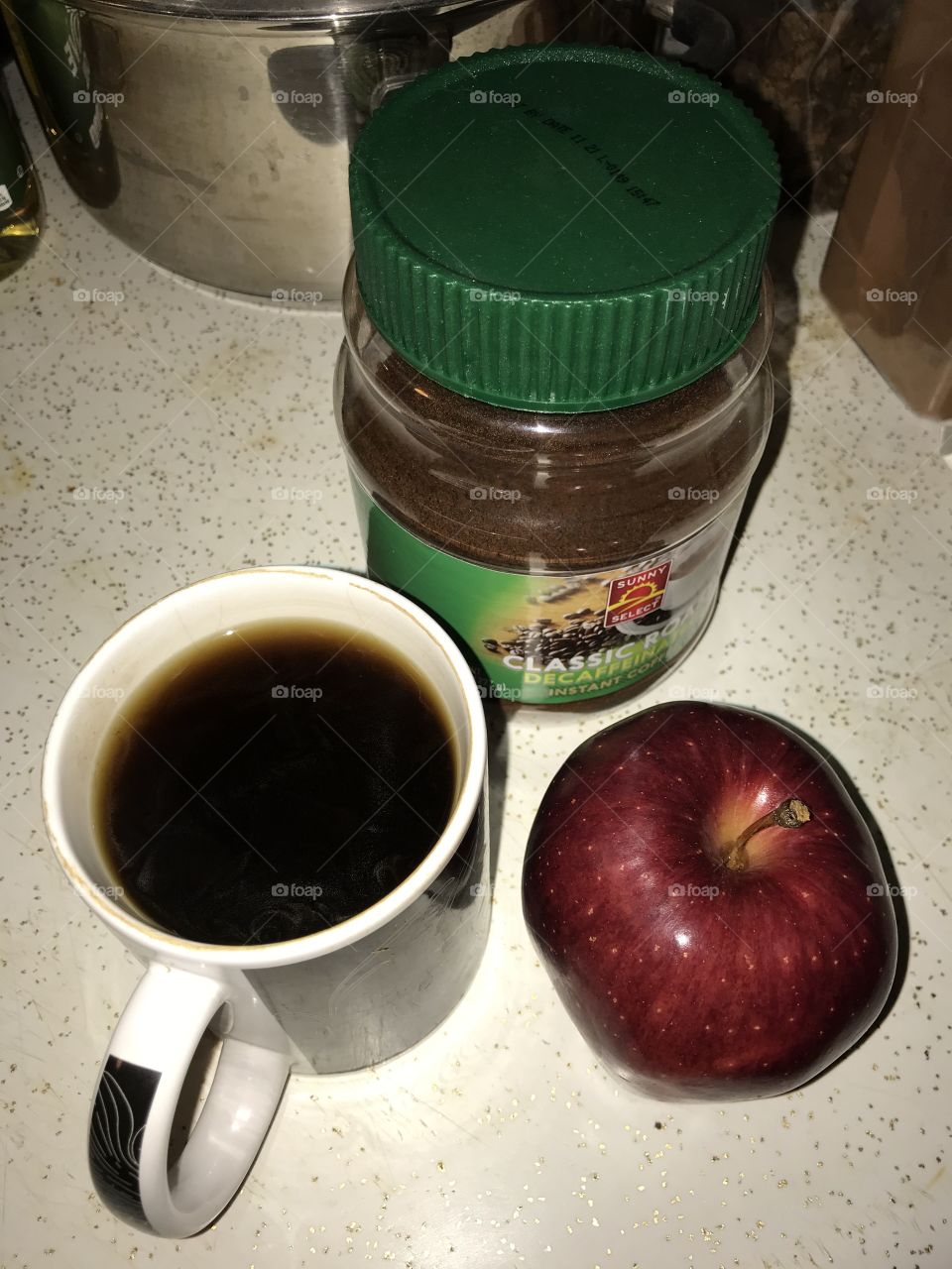 Snack time with instant black coffee and an apple. The two make a healthy combination when one wants something simple to consume after midnight.