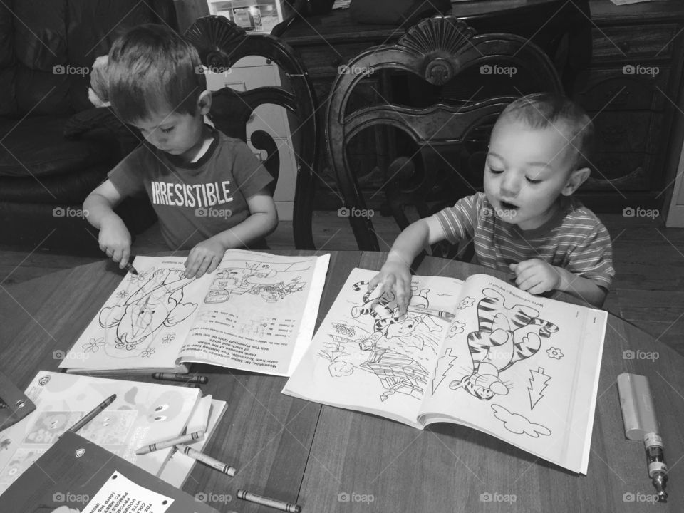 Grandboys coloring in there coloring books with crayons on the kitchen  table.