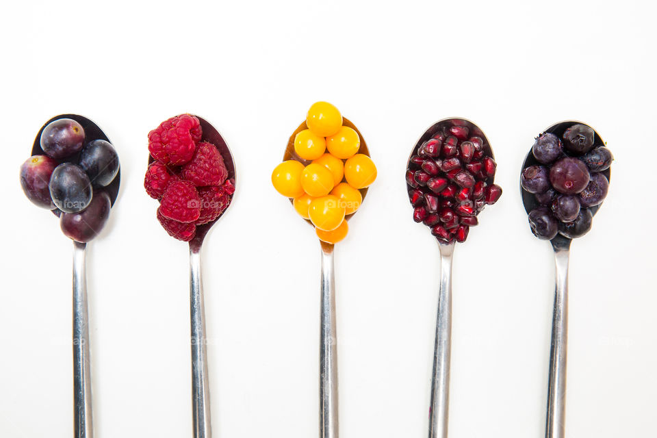 Fresh fruit on silver spoons. Healthy fruit encourages a healthy lifestyle. Fresh summer fruit for vitamins and minerals as part of a healthy diet.