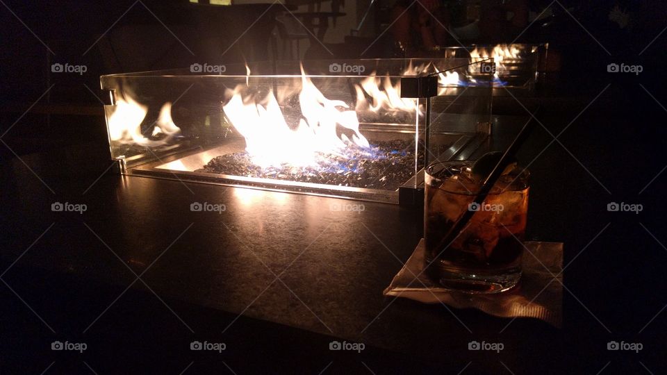 A cocktail by the fire at night