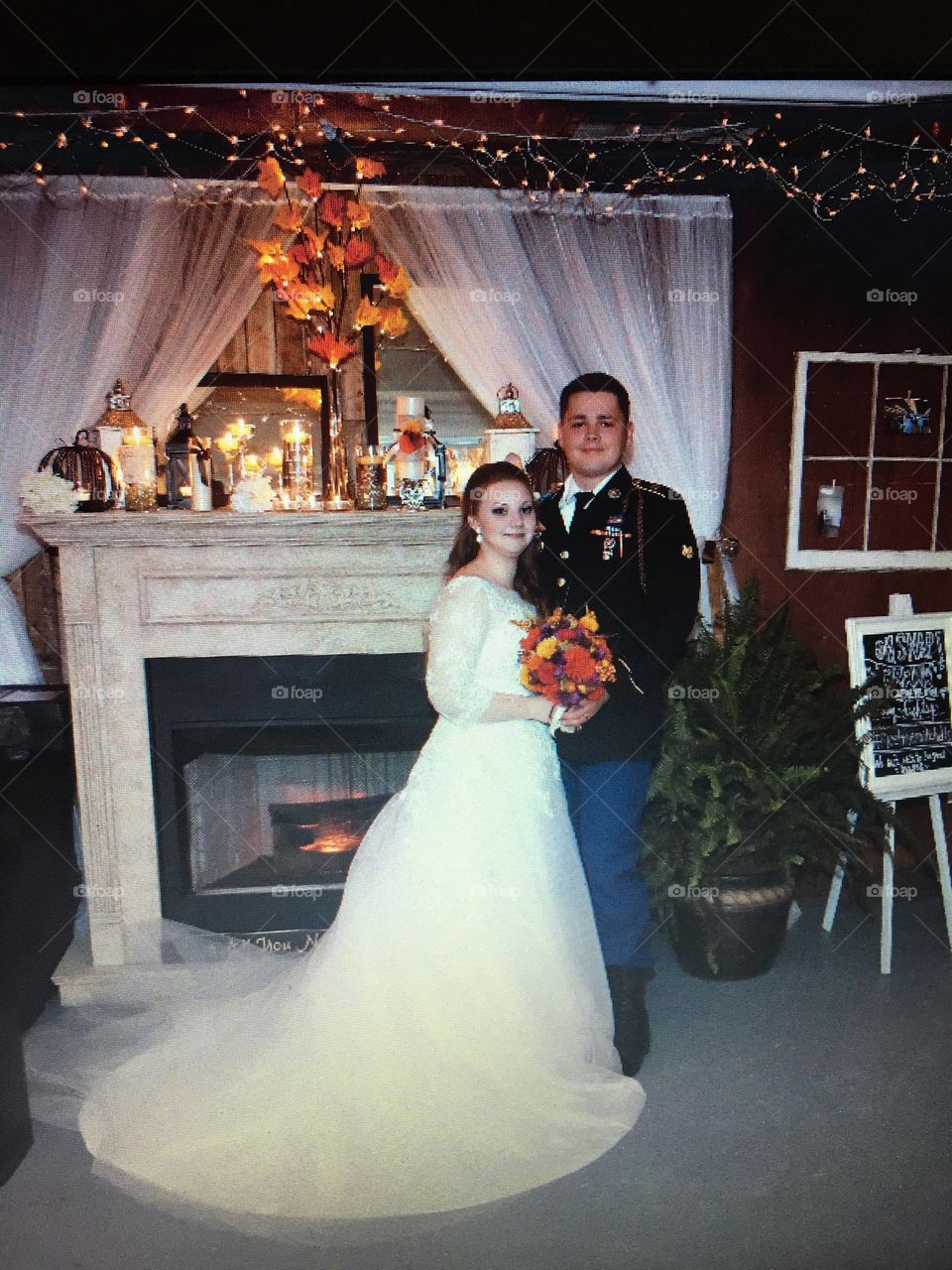Bride and Groom Pausing for a photograph in front of fireplace just before reception begins. 