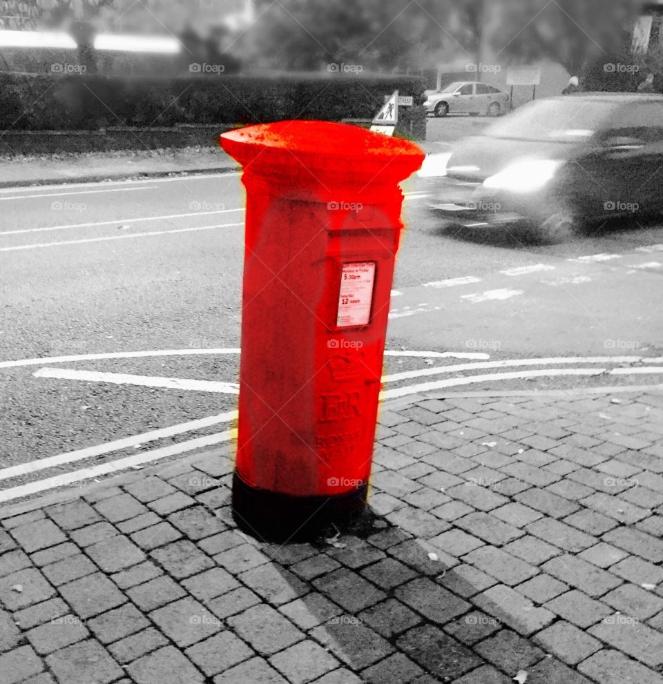 Red traditional post box. Slanting postbox on street corner.