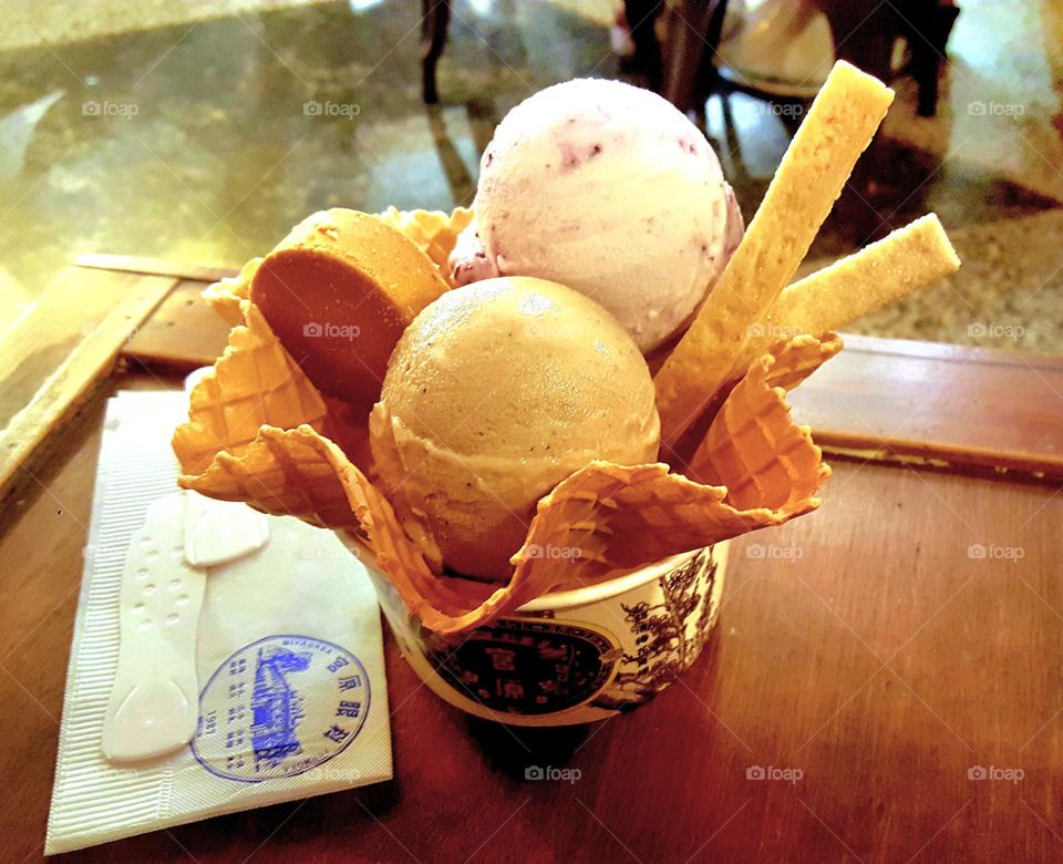 Two balls of ice cream with shortbread, biscuit sticks and pineapple cake