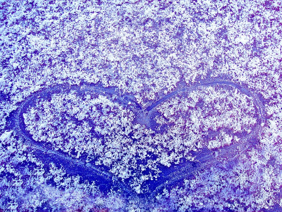 Blue heart on ice close up background winter season cold weather