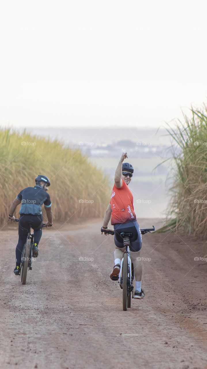 Amigos descendo a ladeira de bicicleta feliz.