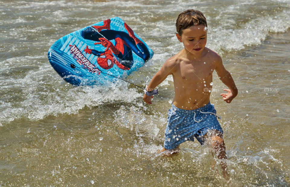 Portrait of boy holding body board