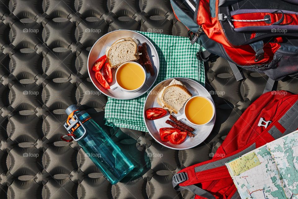 Breakfast at camping outdoors. Plates with sandwiches on outdoor mat. Concept of camp life