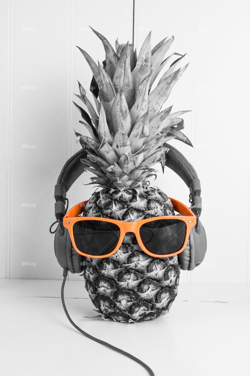 Black and white shot of a pineapple wearing coloured glasses