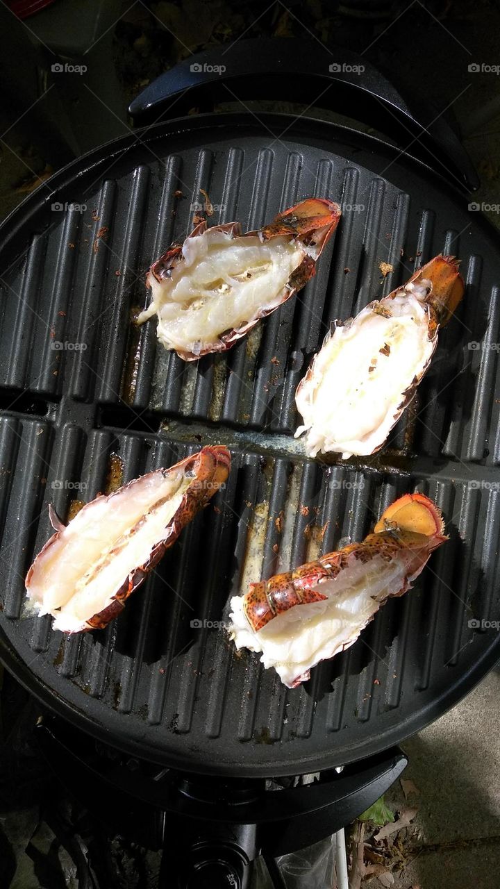 Lobster tails on a electric grill  seasoned with garlic and butter