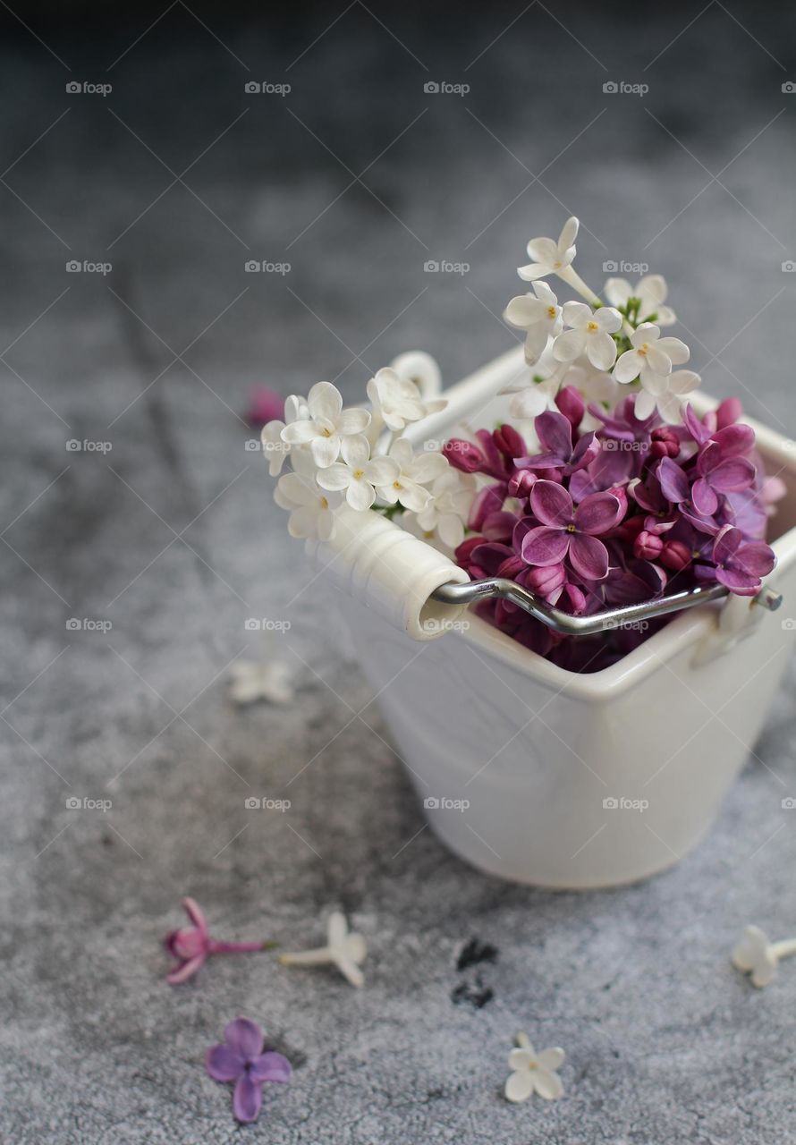 A bouquet of lilacs in a white vase