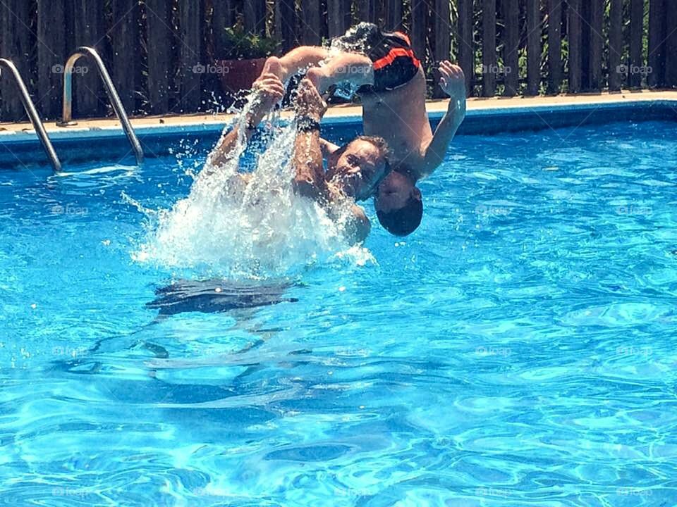 Father and son enjoying in resort pool